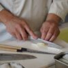 person in white button up shirt holding silver knife