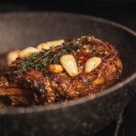 cooked meat with green vegetable on black ceramic plate