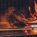 person barbecuing meat