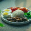 Plate of rice, eggs, meat, and vegetables