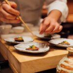 a person holding a chopstick over a plate of food