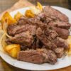 a white plate topped with steak and potatoes