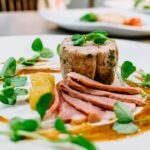 selective focus photography of cooked meat on round white plate