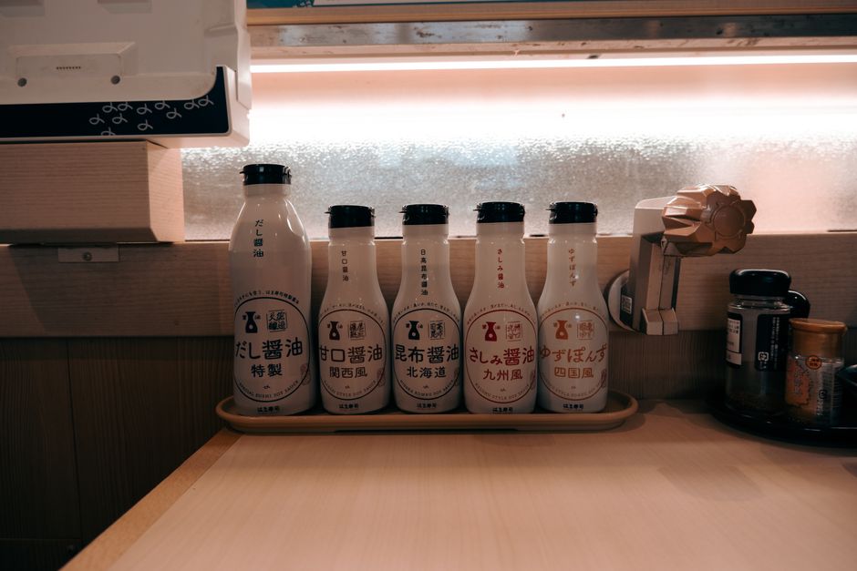A variety of sauce bottles neatly arranged on a kitchen counter in Toyohashi, Japan.