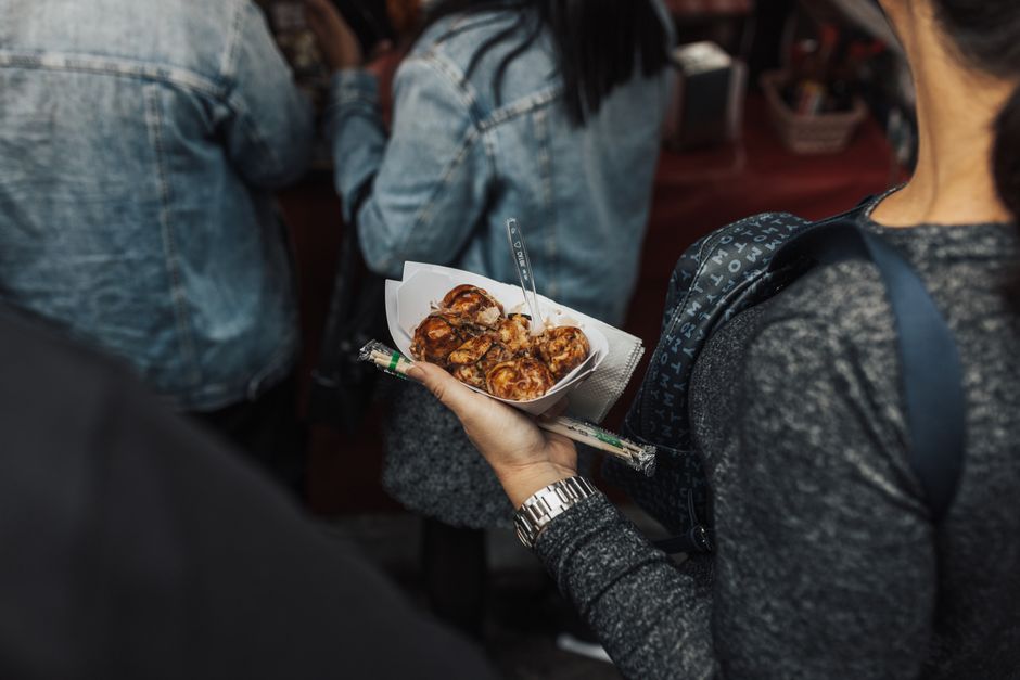 Enjoy the authentic taste of Japanese street food with freshly cooked takoyaki served in a bustling market setting.