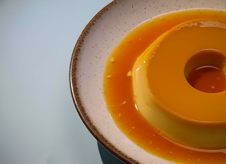 型から出したプリンのアップ、カラメルソースが縁からとろけている様子