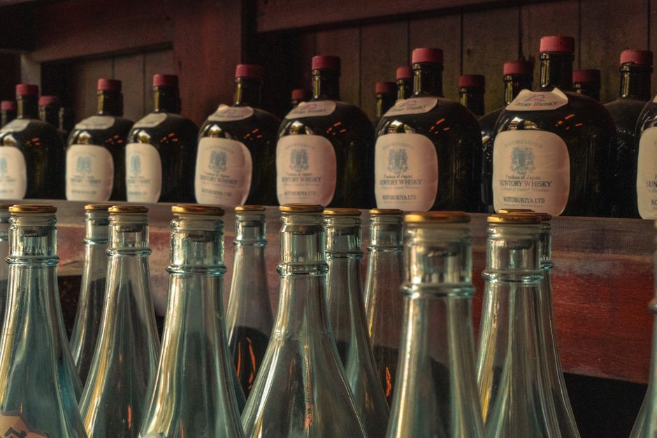 木の樽の上に横たえられた日本酒の瓶