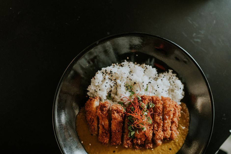 黒い器に盛られたご飯とカツカレー