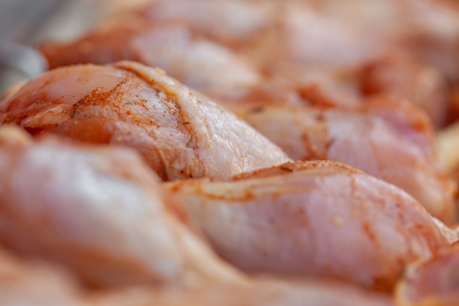 スパイスをまぶした鶏もも肉のクローズアップ、皮付きの断面