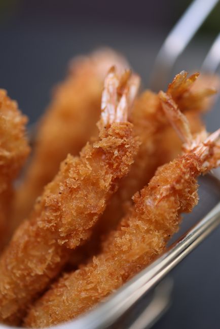 かごに入ったサクサク衣のエビフライのクローズアップ