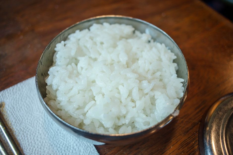 布の上に置かれた茶碗に盛った白いご飯