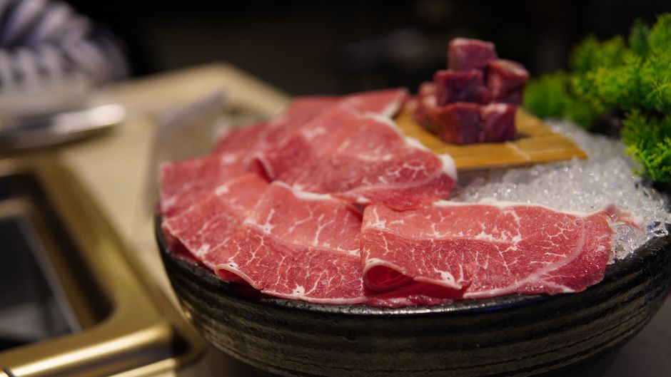 氷の上に置かれた牛肉の塊とすき焼き用食材