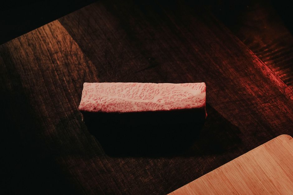 暗い背景に置かれた霜降り牛肉一切れ