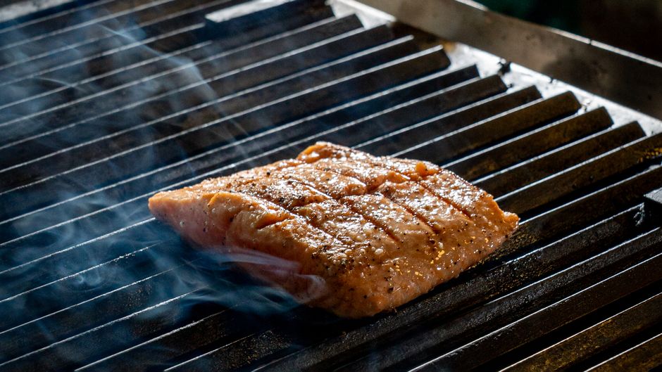 グリルの網で焼かれる鮭の切り身