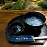 透明な麺状の食材をつゆにつけて食べる様子