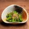 鰹節をのせた緑の唐辛子の炊いた一皿