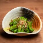 鰹節をのせた緑の唐辛子の炊いた一皿