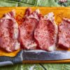 まな板に並べた豚肉の切り身とナイフ