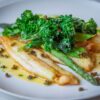 白身魚のポワレと青菜を盛り付けた皿
