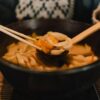 黒い鍋から取り分けるおでんの具材
