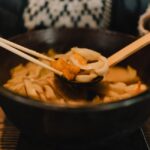 黒い鍋から取り分けるおでんの具材