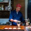 和装の店主が立つ日本の飲食店の店内