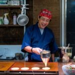 和装の店主が立つ日本の飲食店の店内