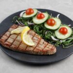 網目の焼き目がついたマグロのステーキとサラダの盛り付け