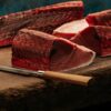 包丁で切り分けられたカツオとマグロの柵、酒盗の原料になる赤身魚