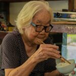箸でご飯を食べている高齢の女性