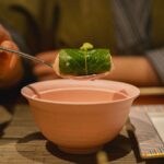 柿の葉のような葉で包んだ寿司にわさびをのせたところ