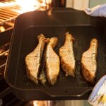 オーブンの天板に並んだ焼き魚の切り身