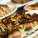 網の上で串に刺した鶏肉を焼くグリル料理