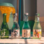 屋外に並べられた色とりどりの日本酒の瓶4本