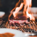 網の上で炎とともに焼かれる牛肉