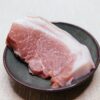黒い皿に乗せた豚肉のクローズアップ
