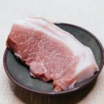 黒い皿に乗せた豚肉のクローズアップ