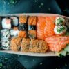 箱に詰め合わせた寿司と海鮮