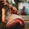 包丁で豚肉の塊を捌いている様子
