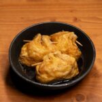 黒い器に盛りつけた厚揚げの煮物