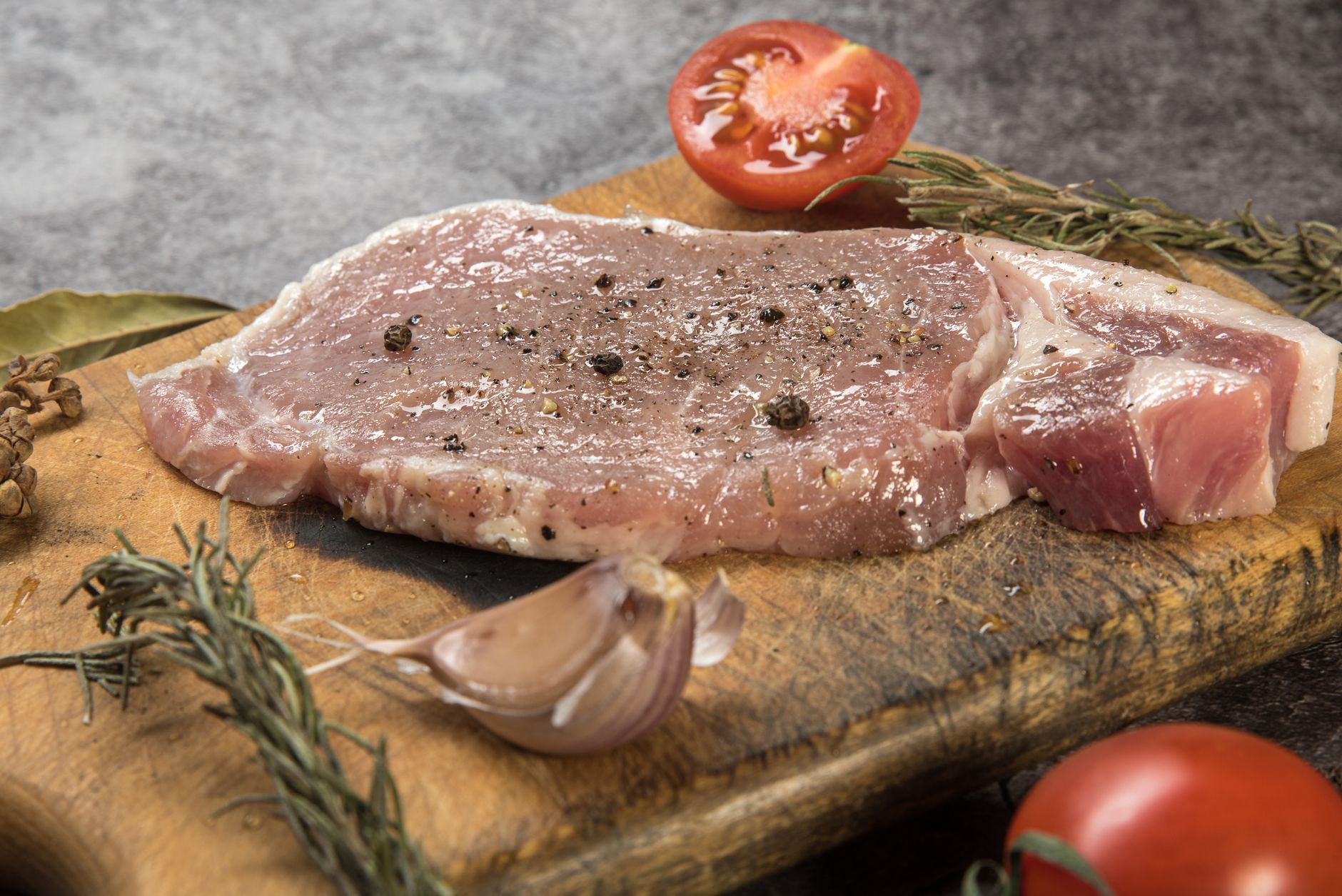 まな板の上に置いた厚切りの豚肉とにんにく