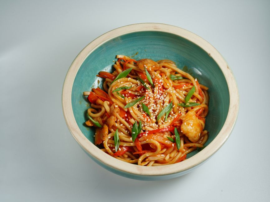 青いボウルに盛られたごま入りの担々麺風の麺
