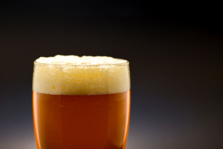 泡がのった琥珀色のビールのグラス