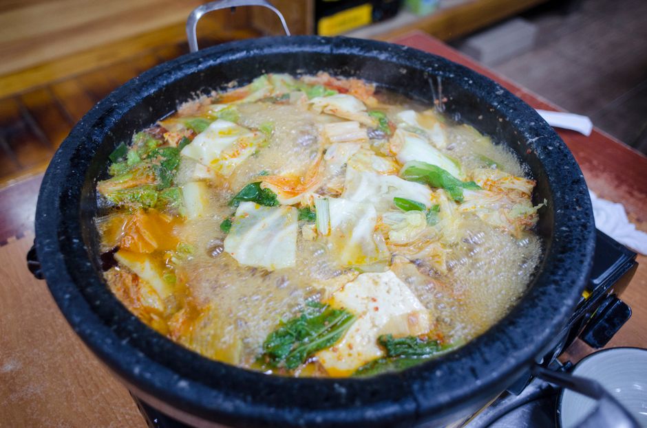 黒い土鍋で煮立つ豆腐と白菜の鍋