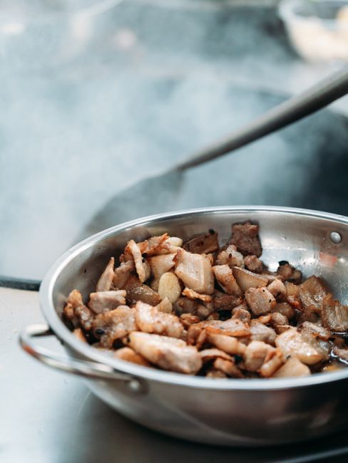 豚肉とにんにくをフライパンで炒めている様子