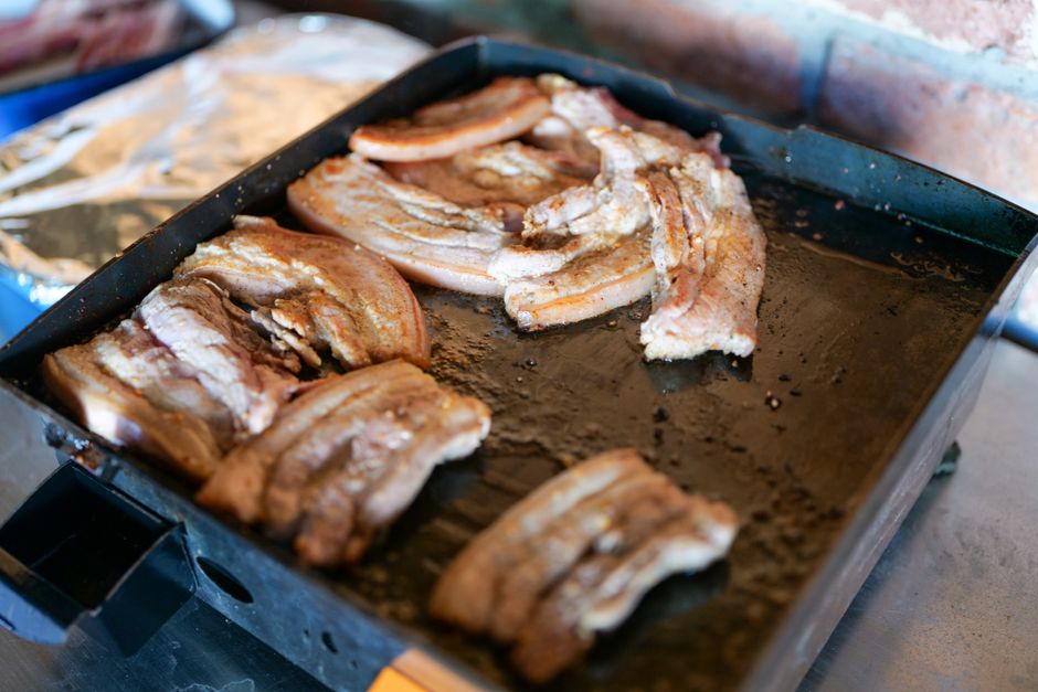 四角い鉄板で焼かれる豚バラ肉のスライス