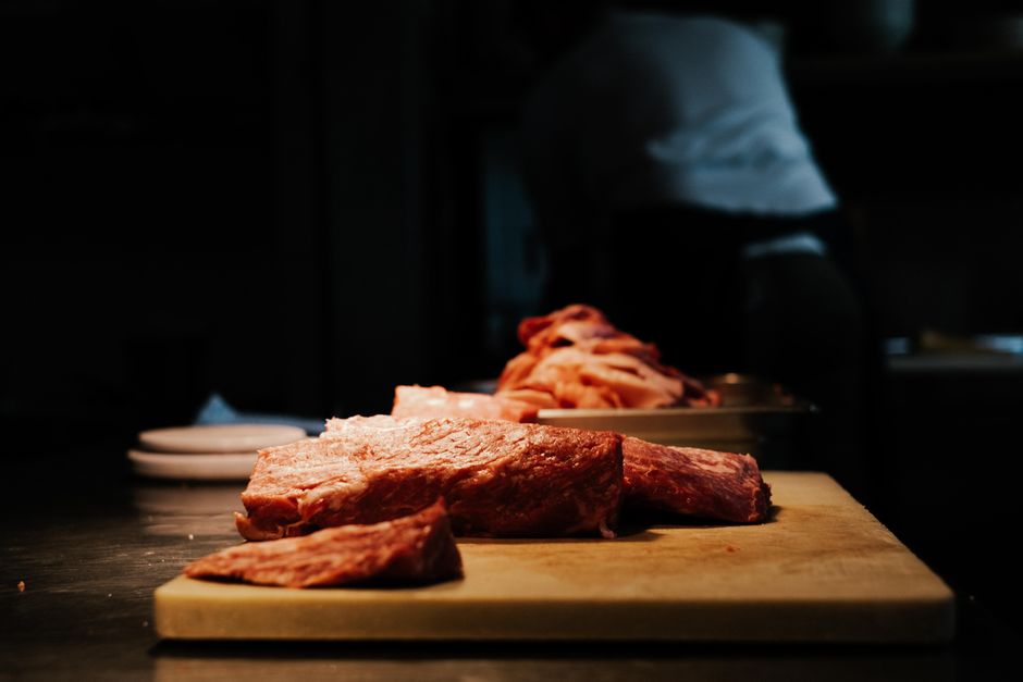 まな板の上に置かれた赤身の生肉の塊