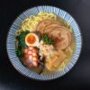 黒い器に入った塩ラーメン。透き通ったスープと具材を上から見た写真
