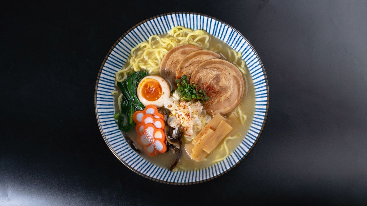 黒い器に入った塩ラーメン。透き通ったスープと具材を上から見た写真