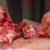 職人がまな板の上で丁寧に部位ごとへ処理する豚肉